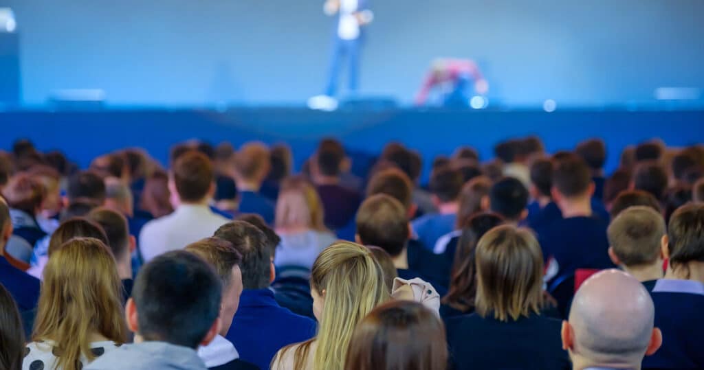 Conference attendees listen to a speaker