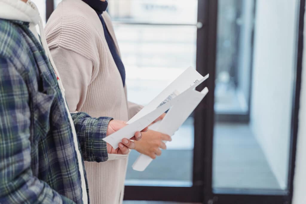 Two people reviewing paperwork indoors, illustrating how to get a general contractor license.