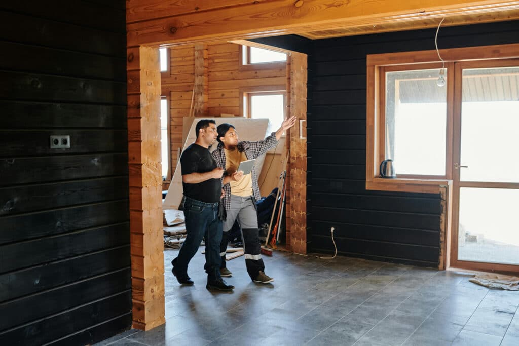 Homeowner inspecting a room under renovation, guided by someone with a home improvement license.