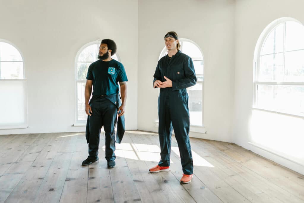 Two licensed general contractors standing in an empty room during a project walkthrough.