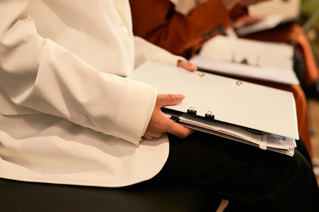 Person reviewing documents in a binder while learning how to get general contractor license.